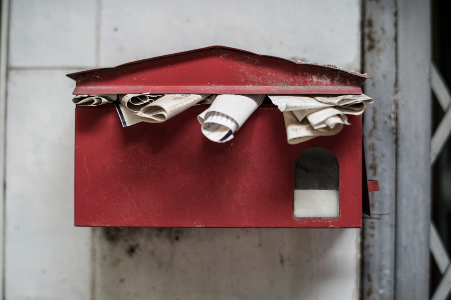 Boîte aux lettres rouge débordant de journaux, Société de distribution de prospectus, quartier ancien de Montpellier