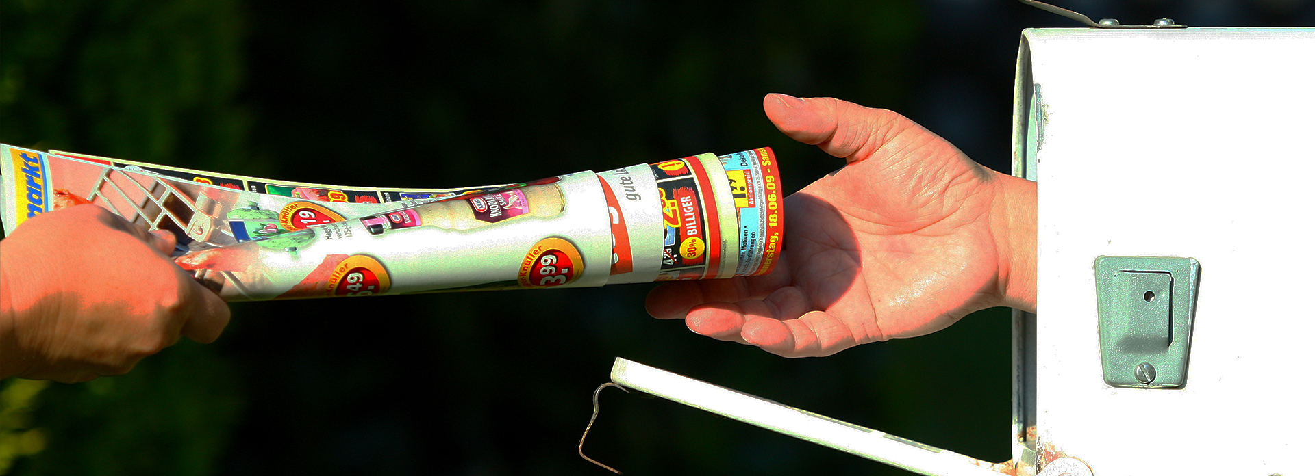 Société de distribution de prospectus à Montpellier remettant des prospectus colorés dans une boîte aux lettres blanche